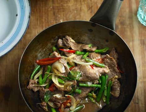 Website recipe Rustic wok with pad thai on a wooden board.