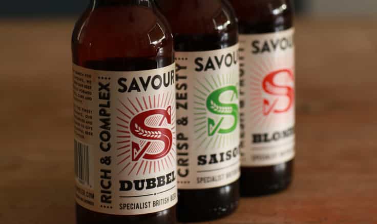 Row of Savour beer bottles with different flavours showing the branding in different colours on each.