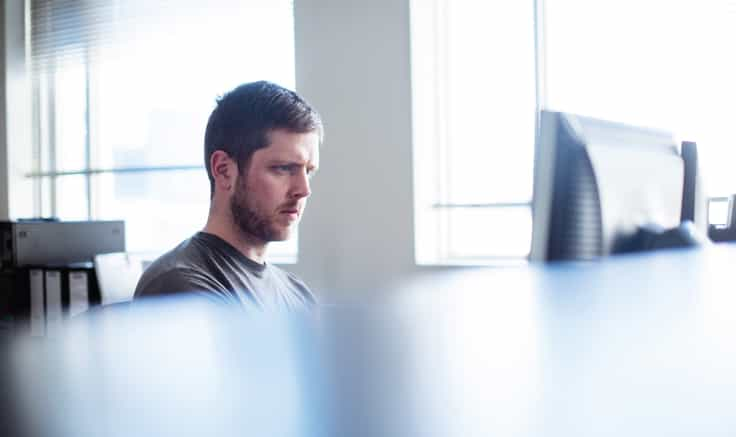 Bright image of a person working at a desktop computer.