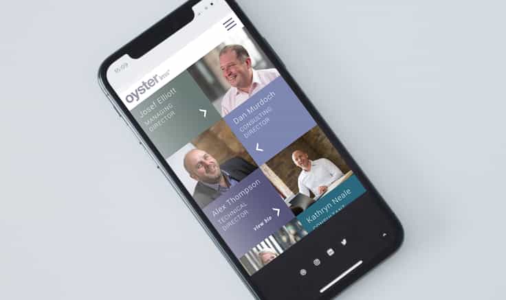Mobile phone on grey background shot from above, showing the Meet the Team page from Oyster IMS website.