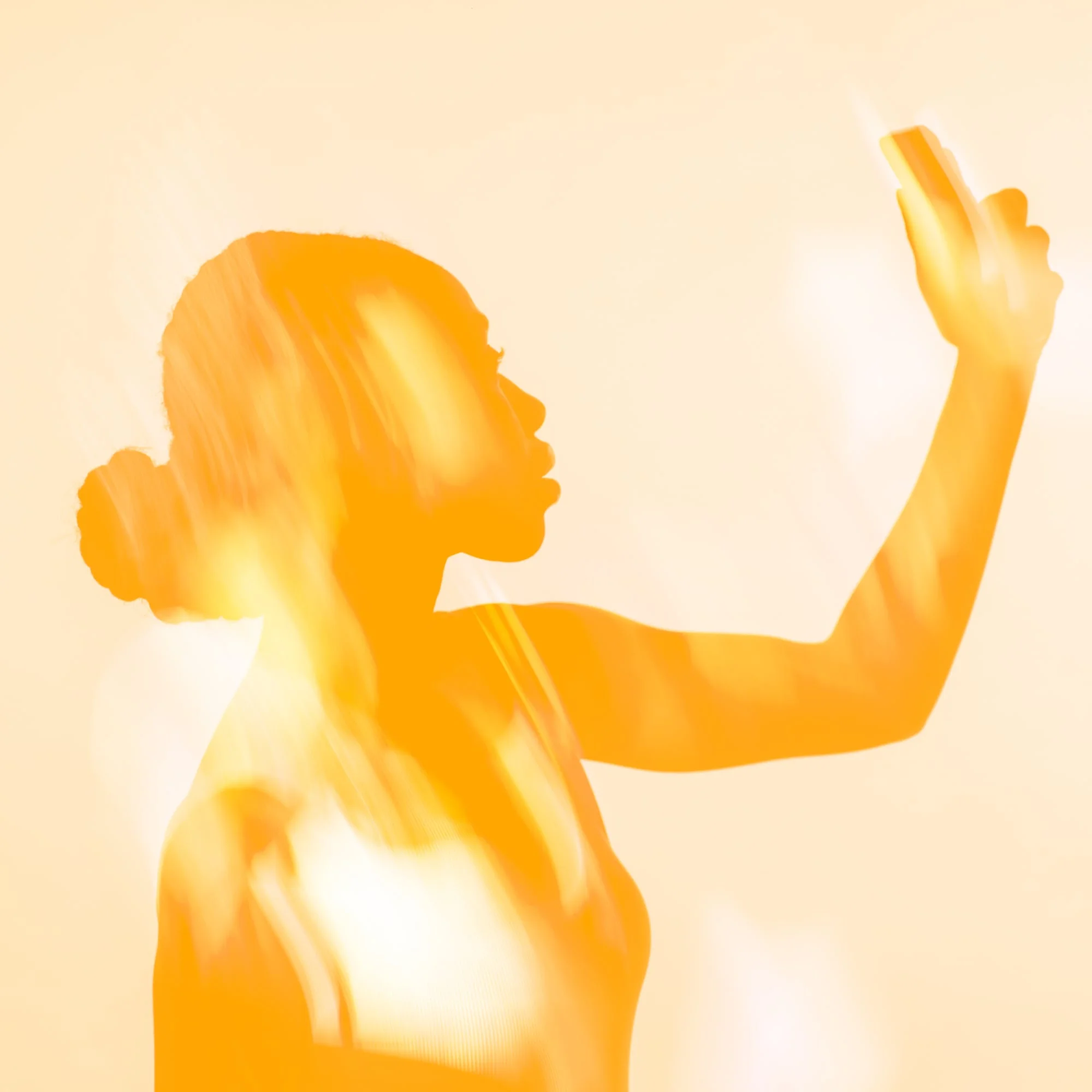 orange glowing silhouette woman holding phone amber background