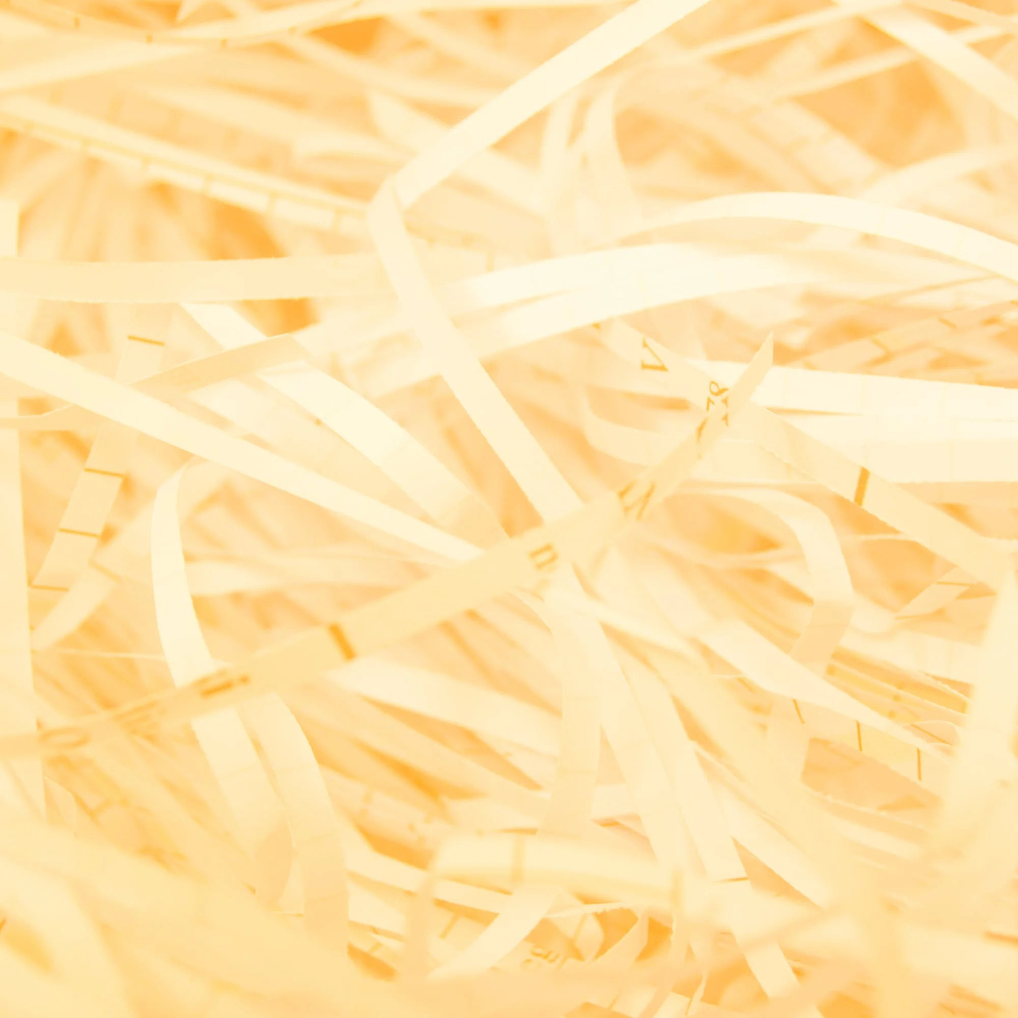 close up shredded paper strips texture cream toned background