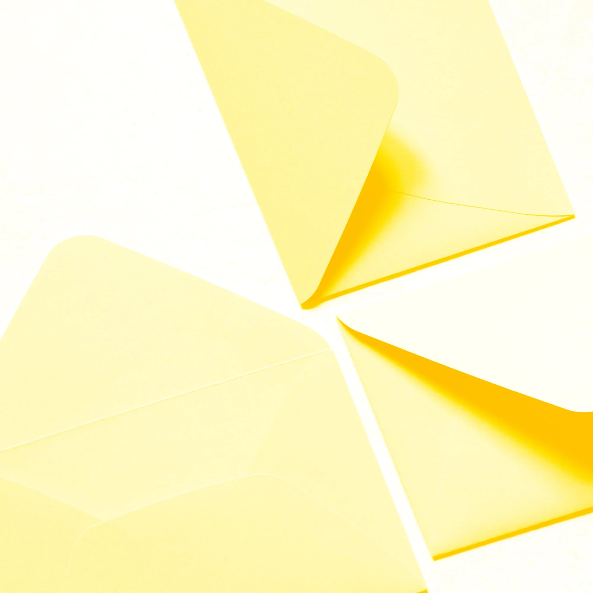 yellow envelopes arranged in fan pinwheel pattern white background