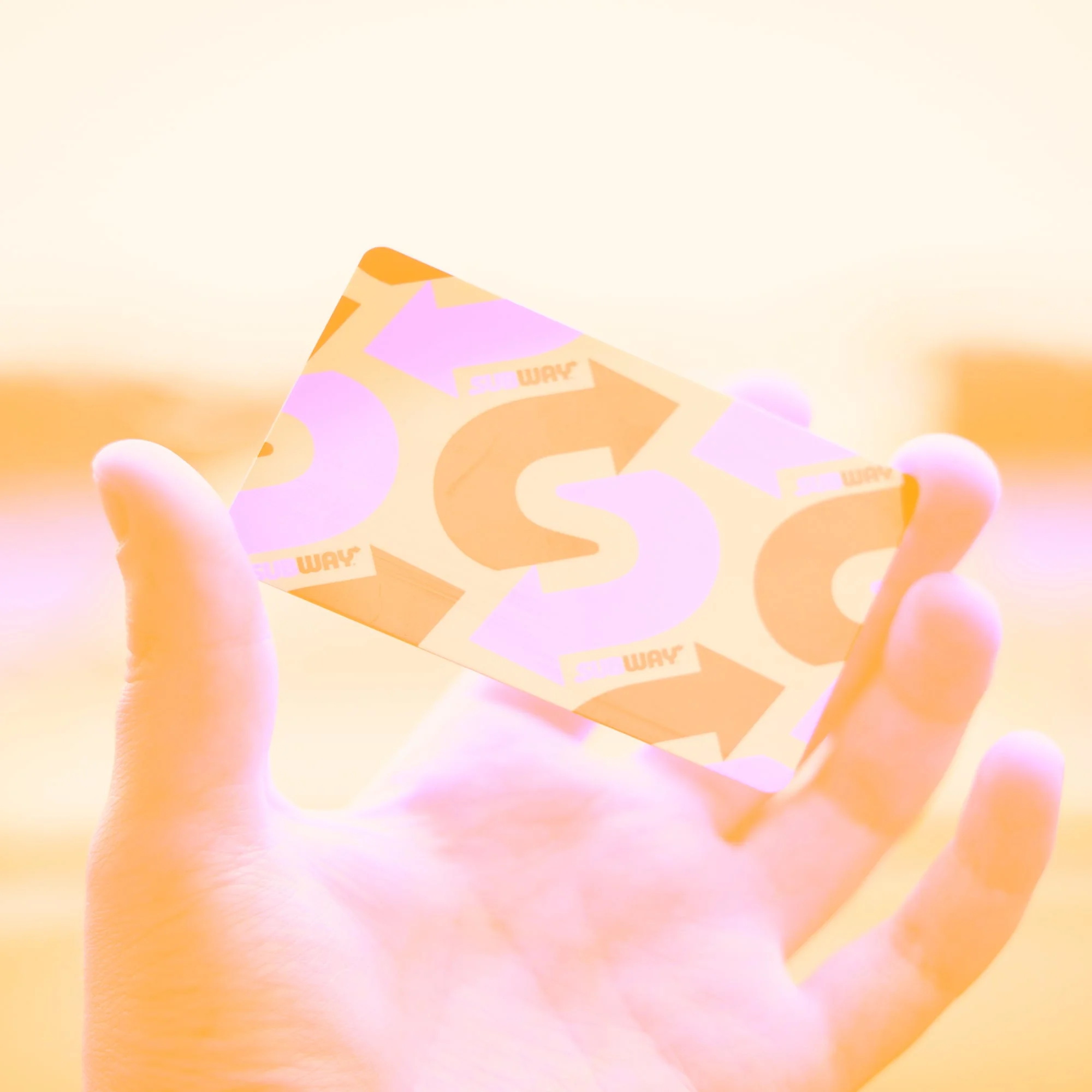 hand holding branded business card with arrow design golden toned