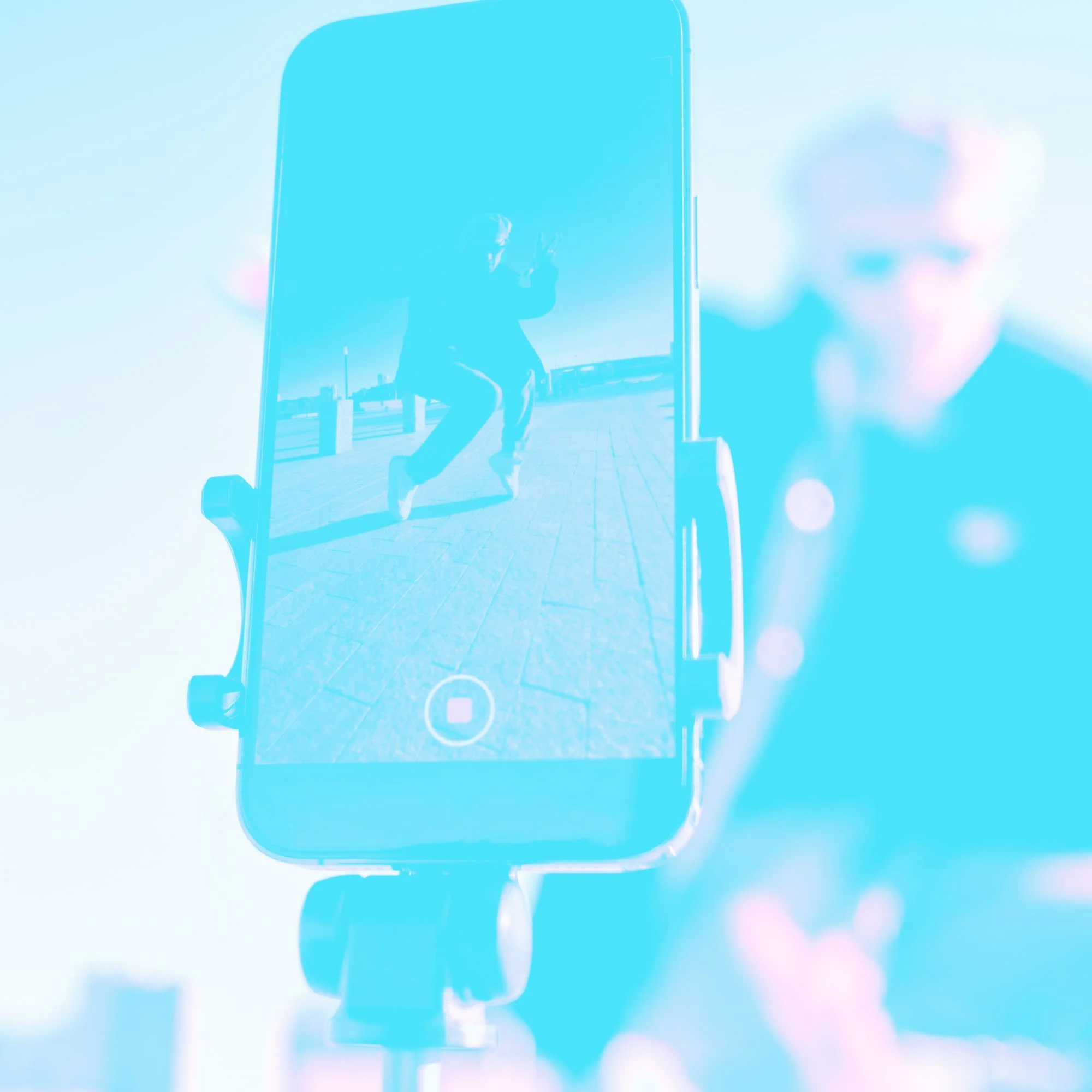 smartphone on tripod recording person dancing outdoors teal toned