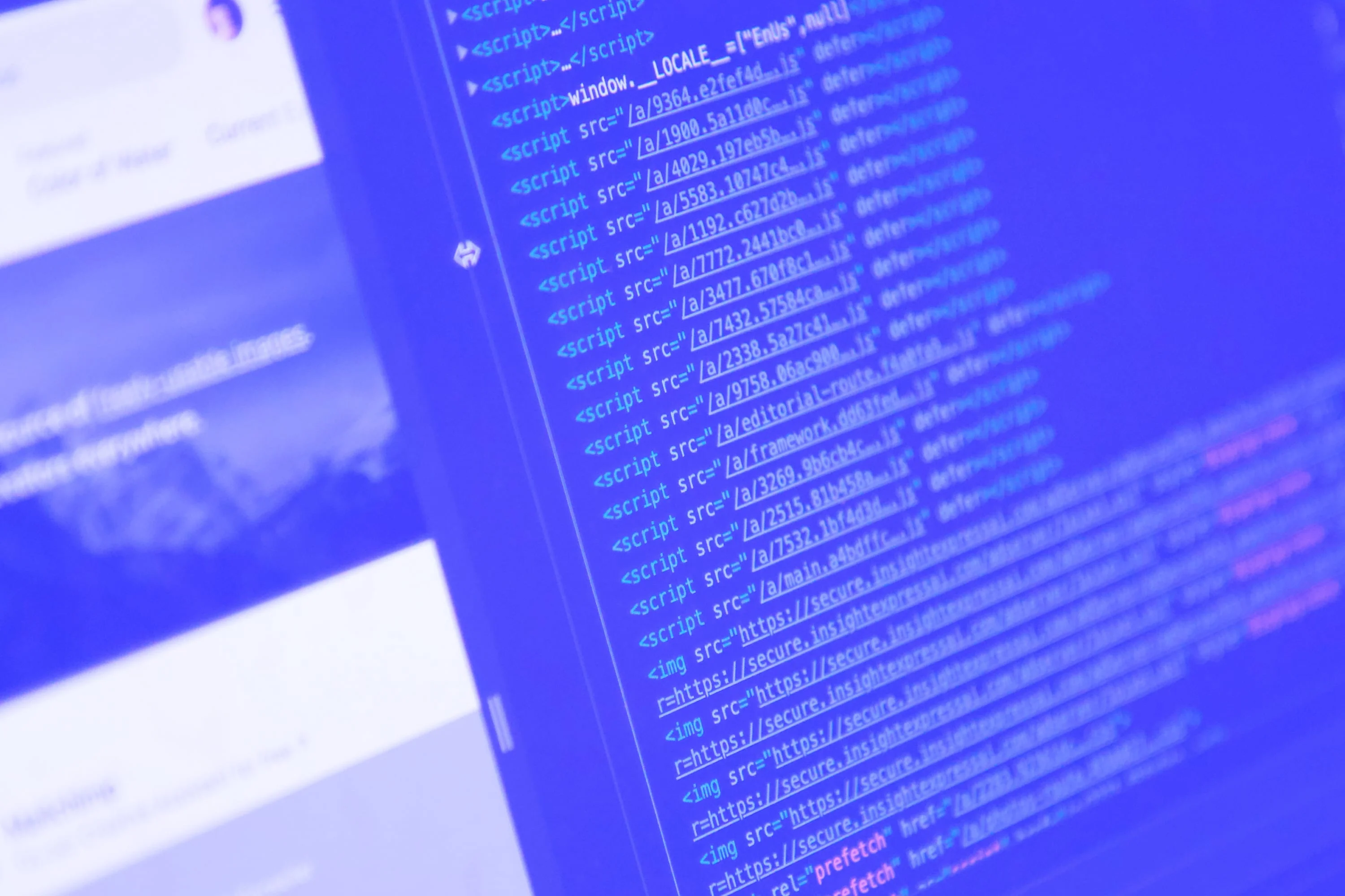 html javascript source code on monitor screen with website preview blue toned