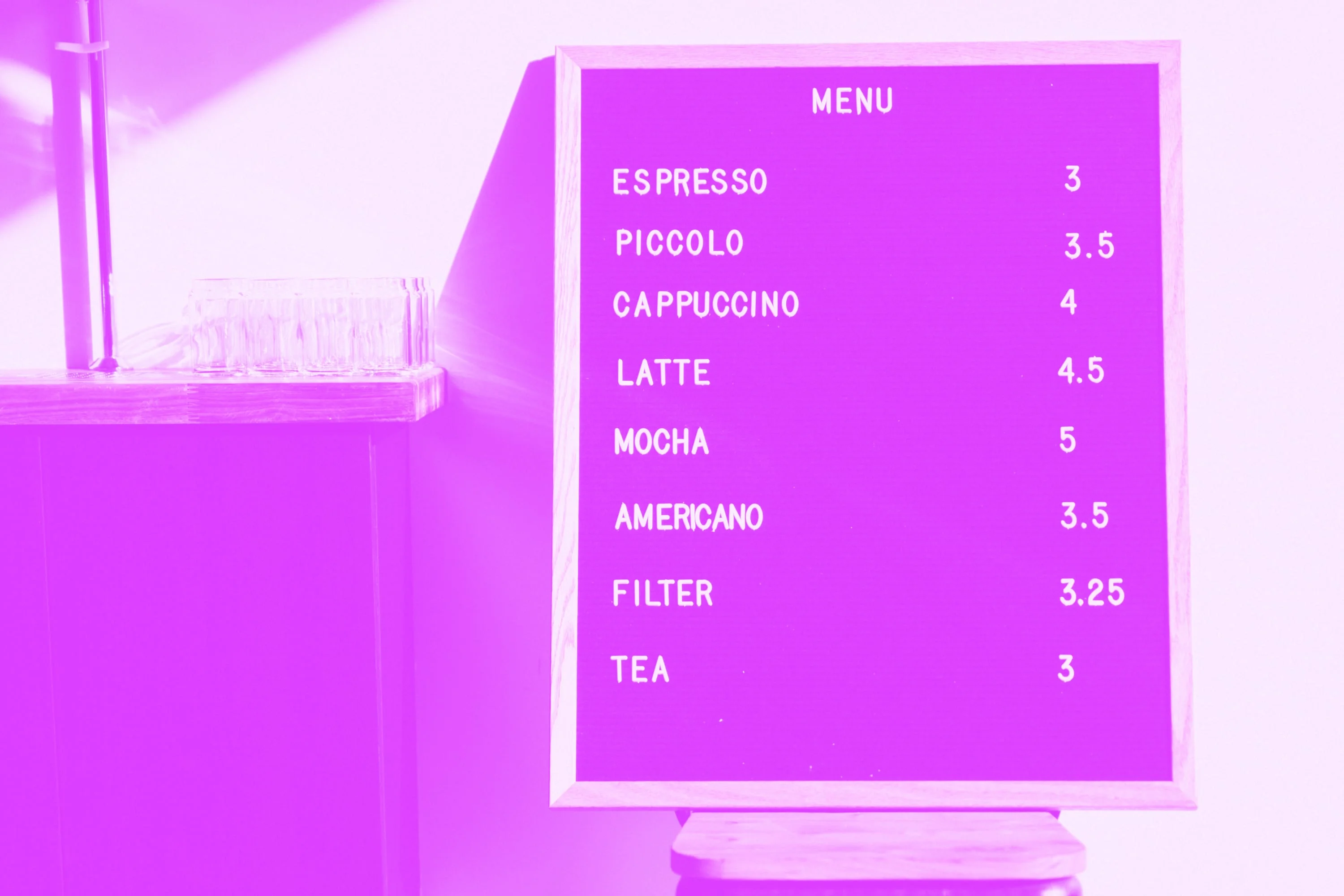 framed coffee shop menu board showing espresso cappuccino latte prices pink purple