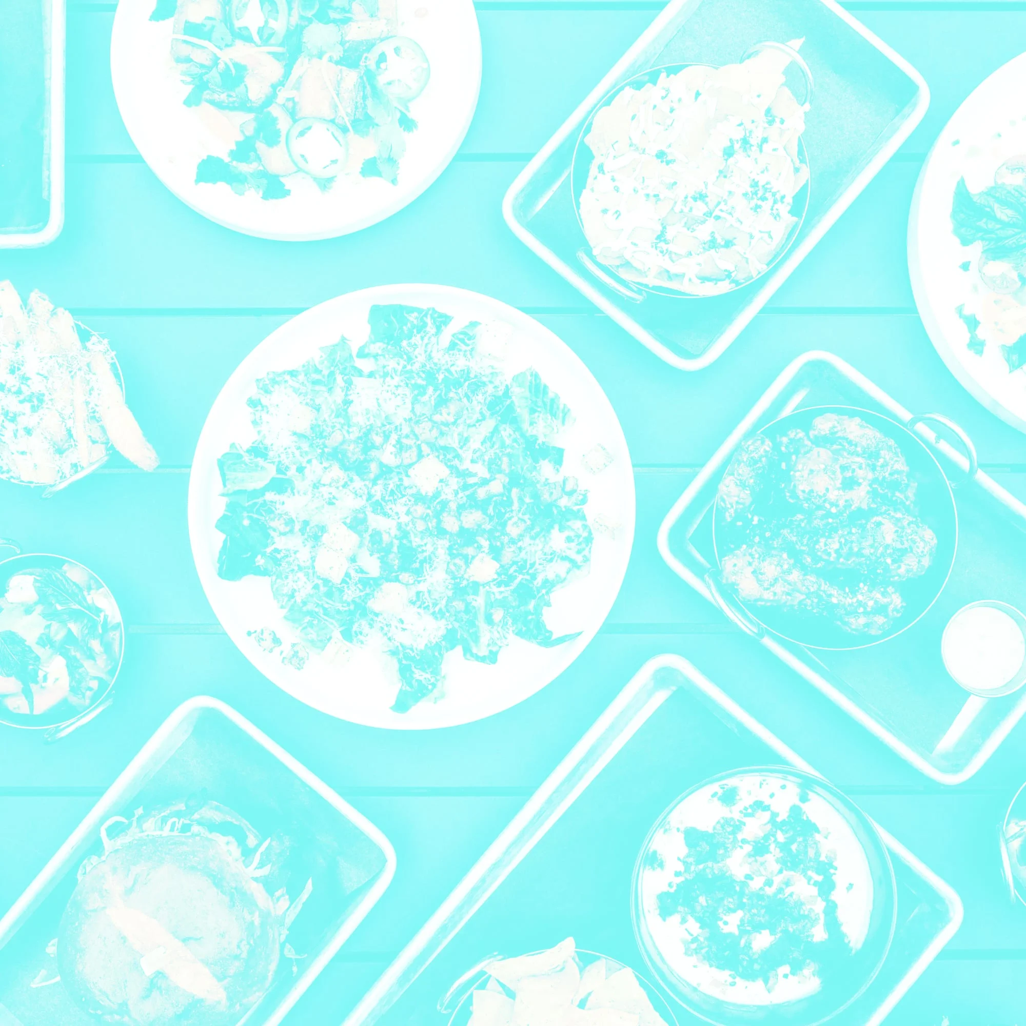 overhead view of multiple food dishes and plates on teal wooden table