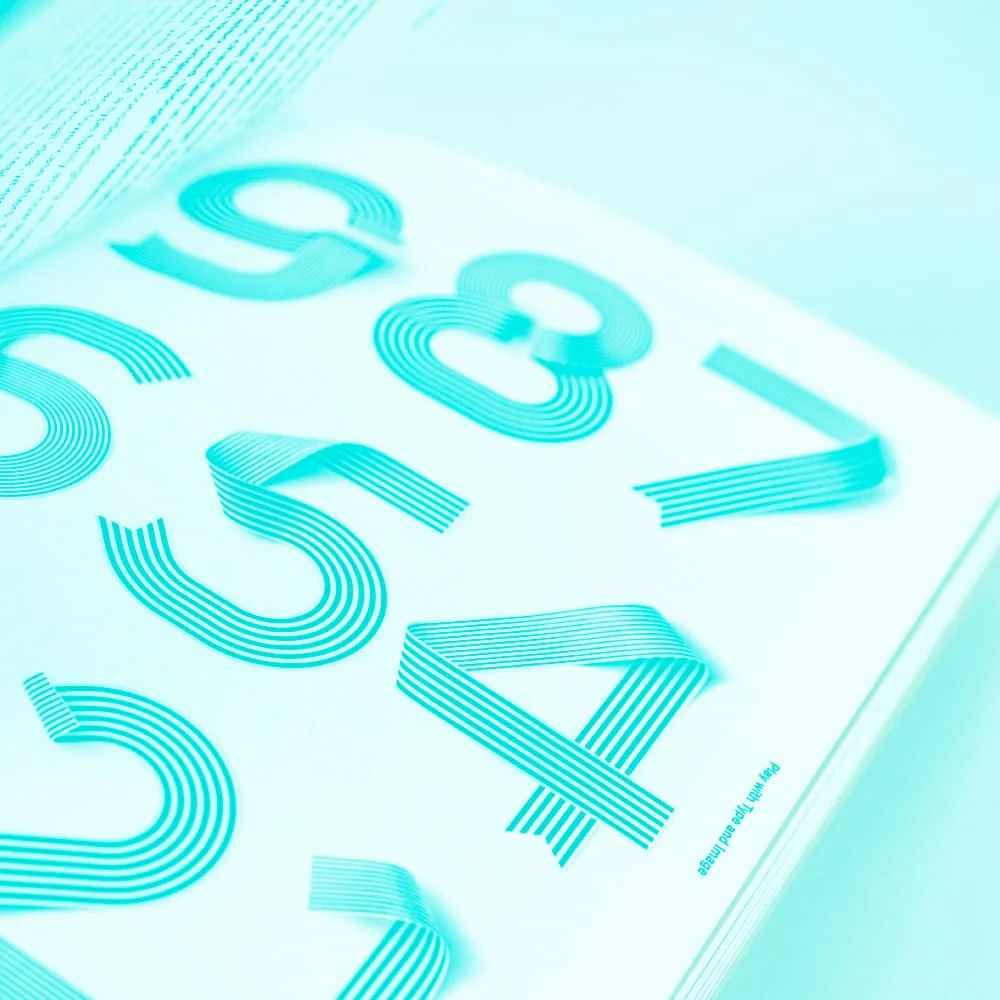 open design book showing decorative lined numbers typography teal toned
