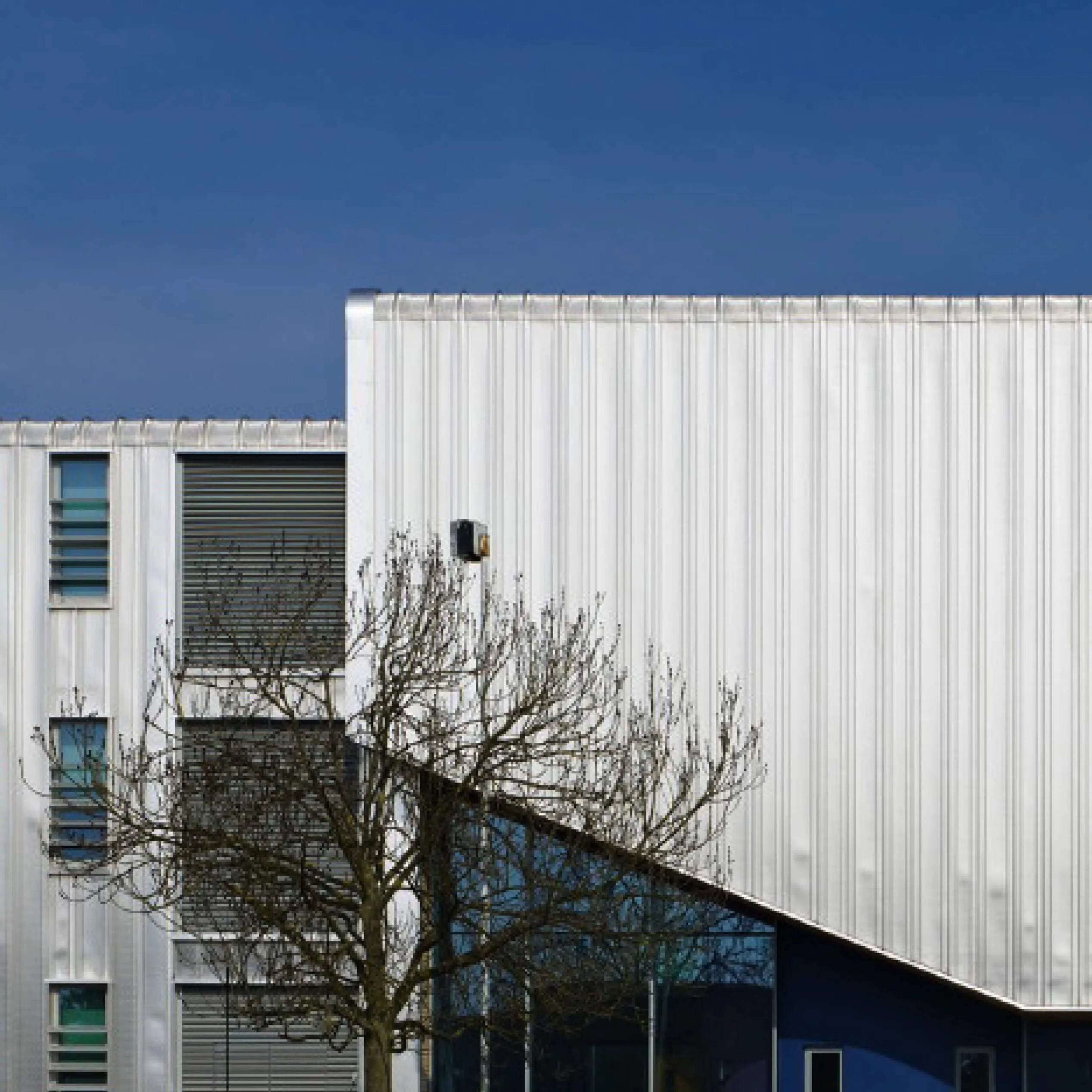Modern building exterior with white cladding and glazed entrance