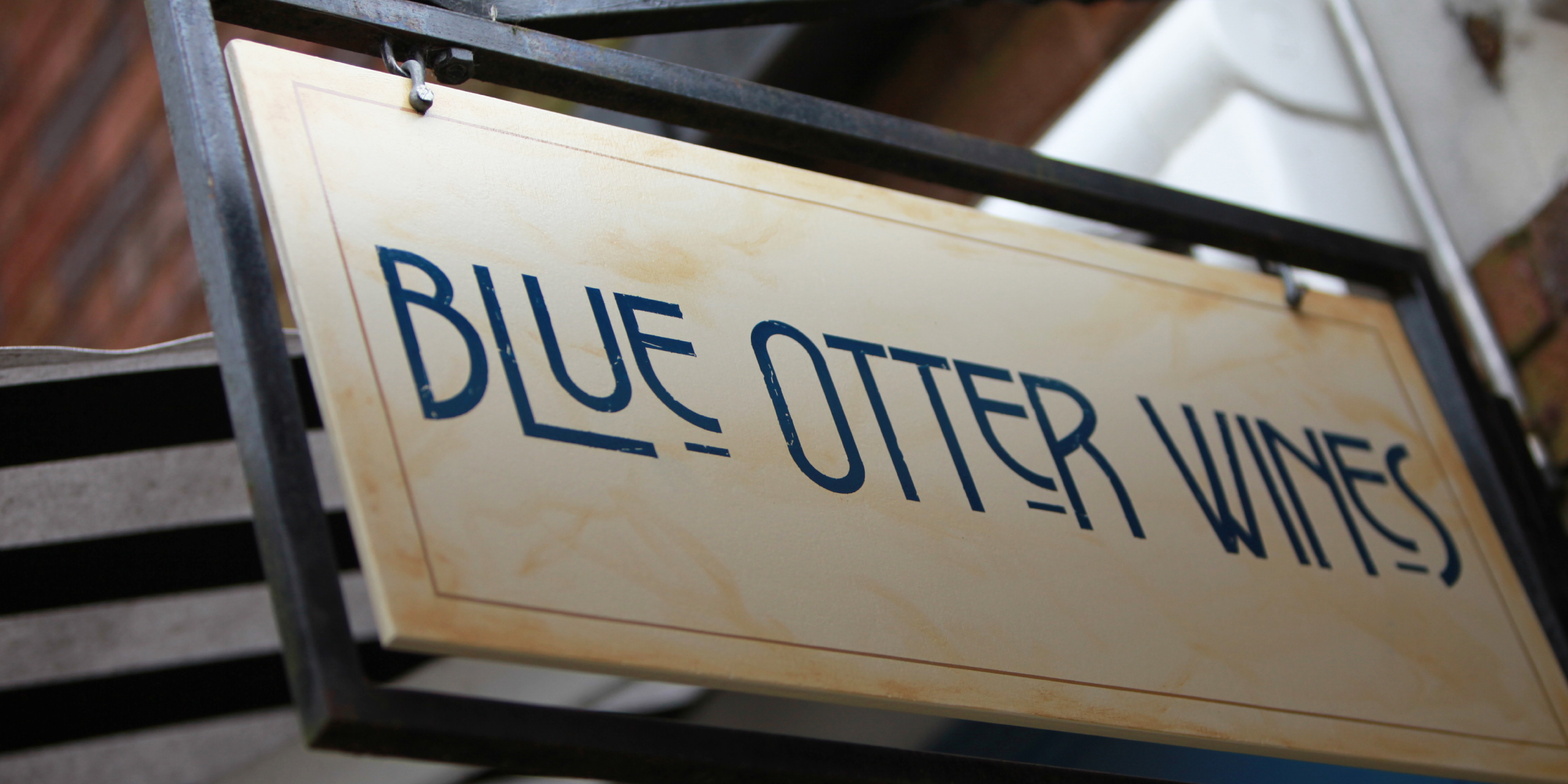 Close-up of Blue Otter Wines lettering on a wooden sign
