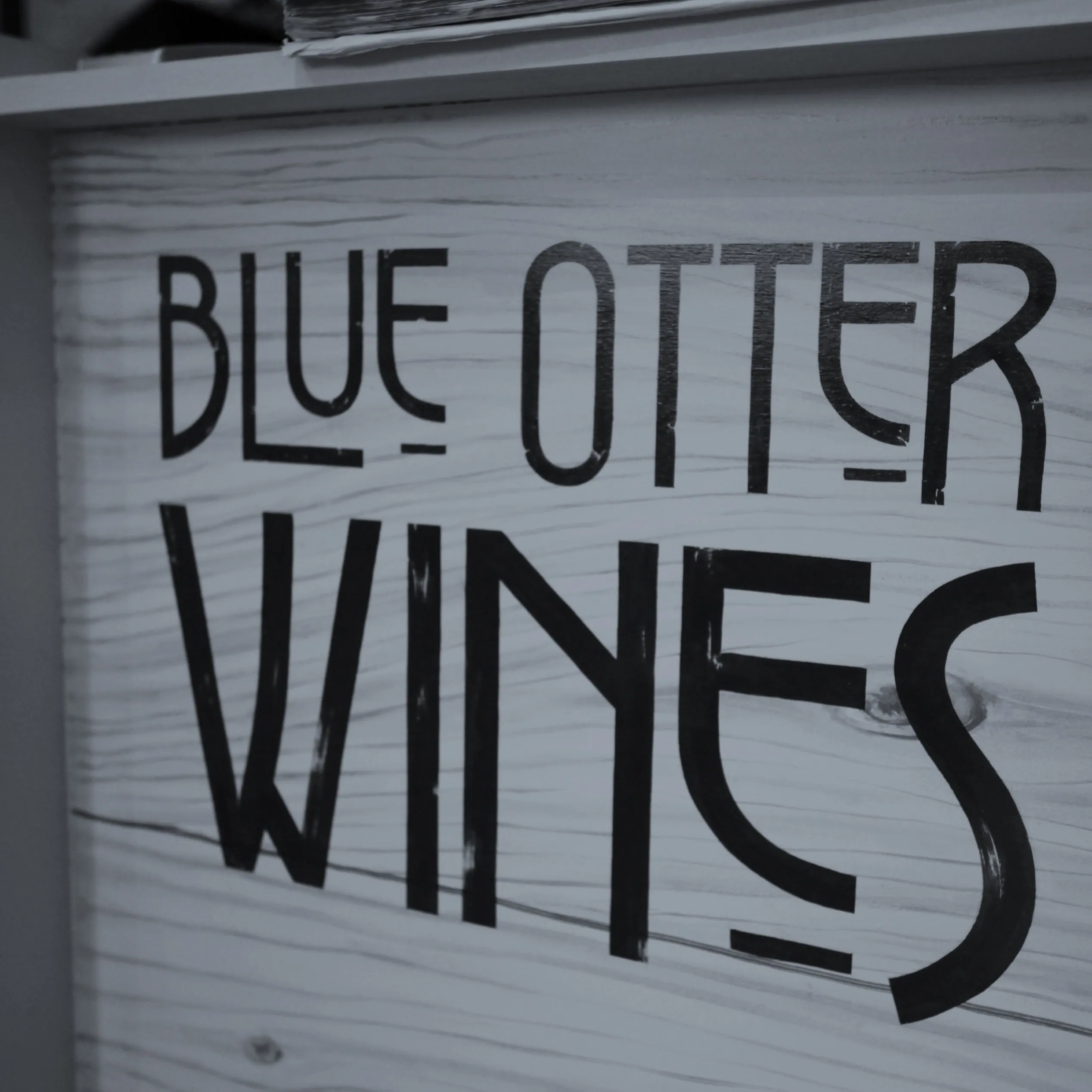 Close-up of Blue Otter Wines lettering on a wooden sign