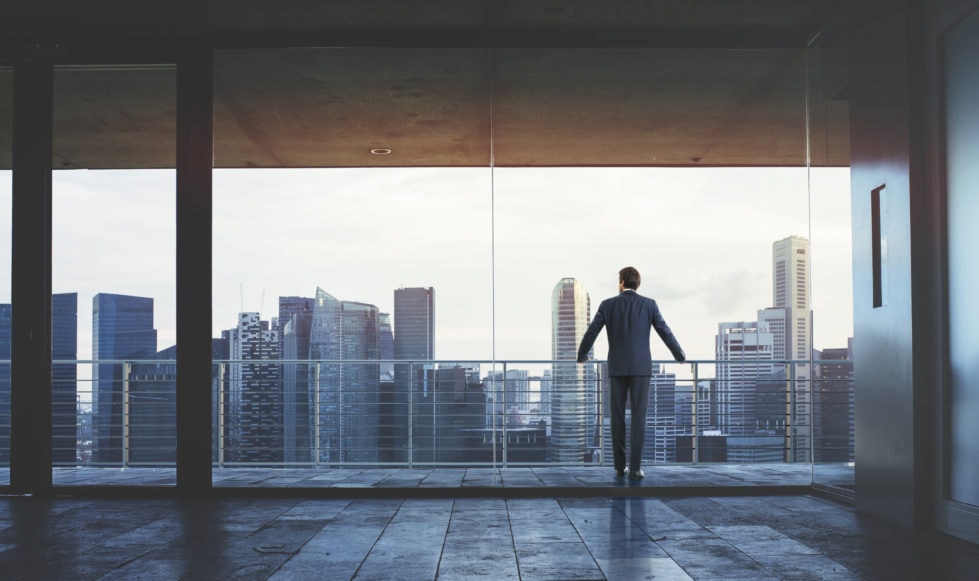 Brand images Suited man stood at a balcony overlooking a london city landscape.