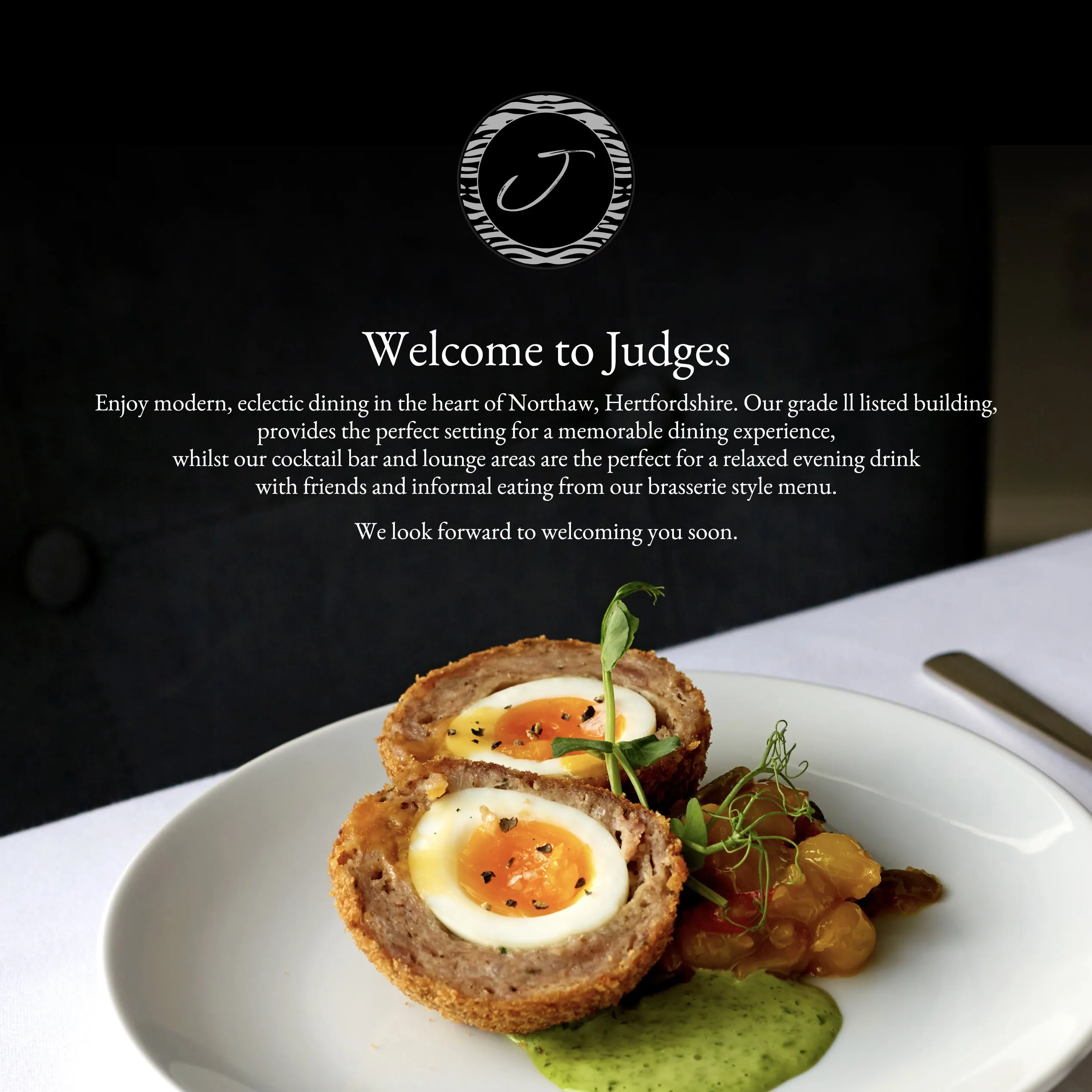 Judges website “Welcome to Judges” section shown over a scotch egg dish on a white plate