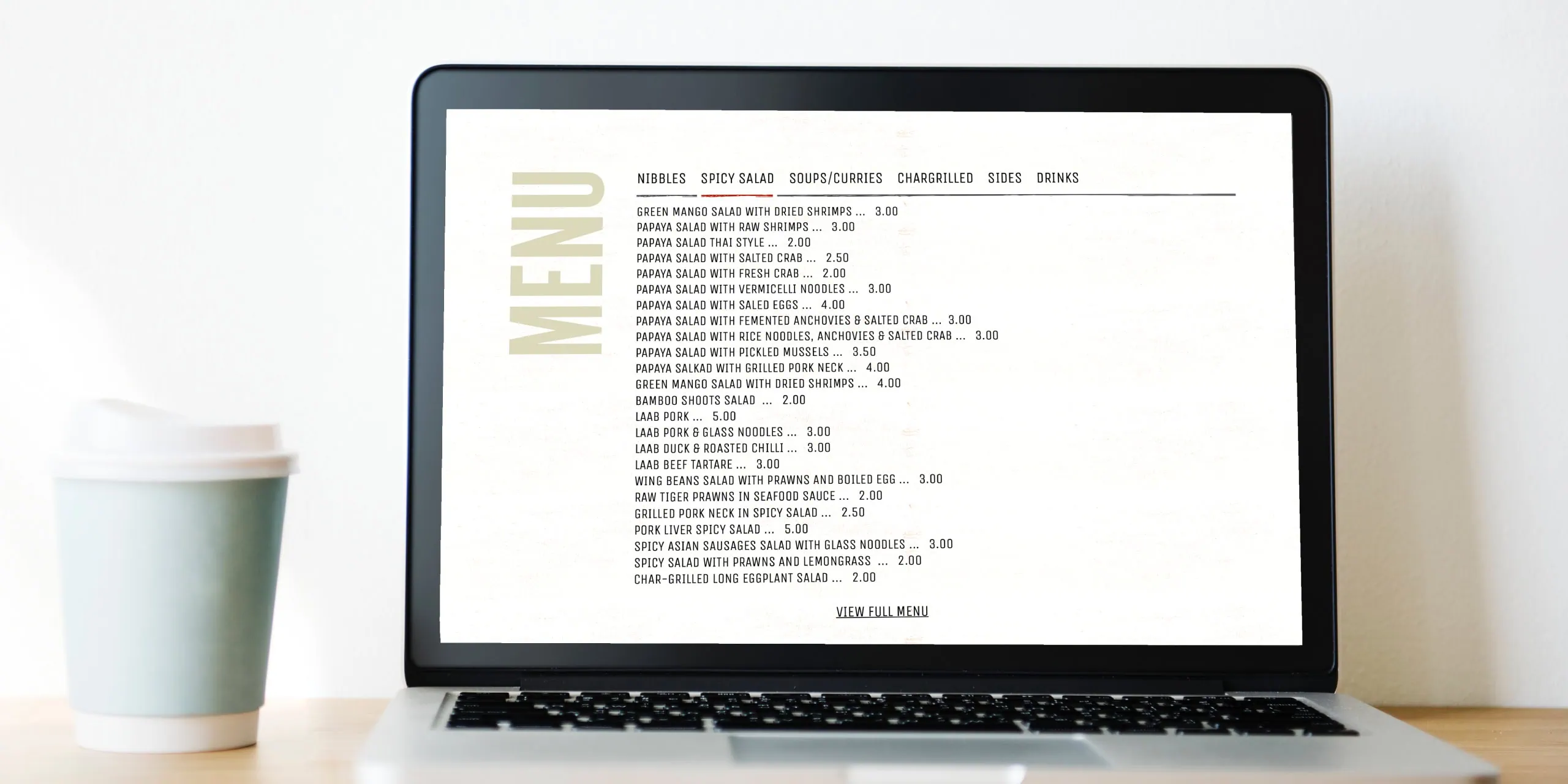 Lao Café menu page shown on a laptop screen with a takeaway coffee on the desk