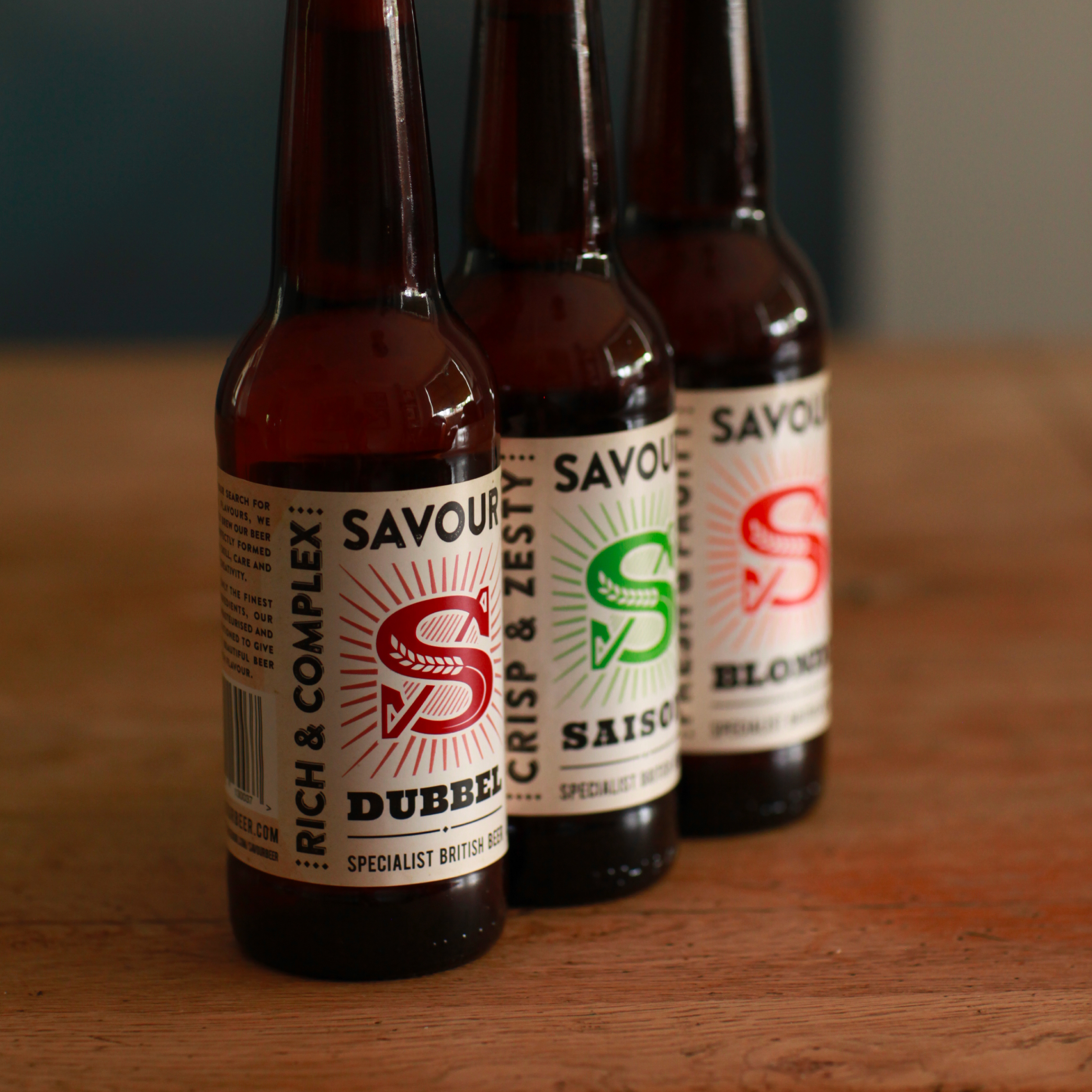 Savour beer bottle lineup showing different label colours and styles in shallow focus