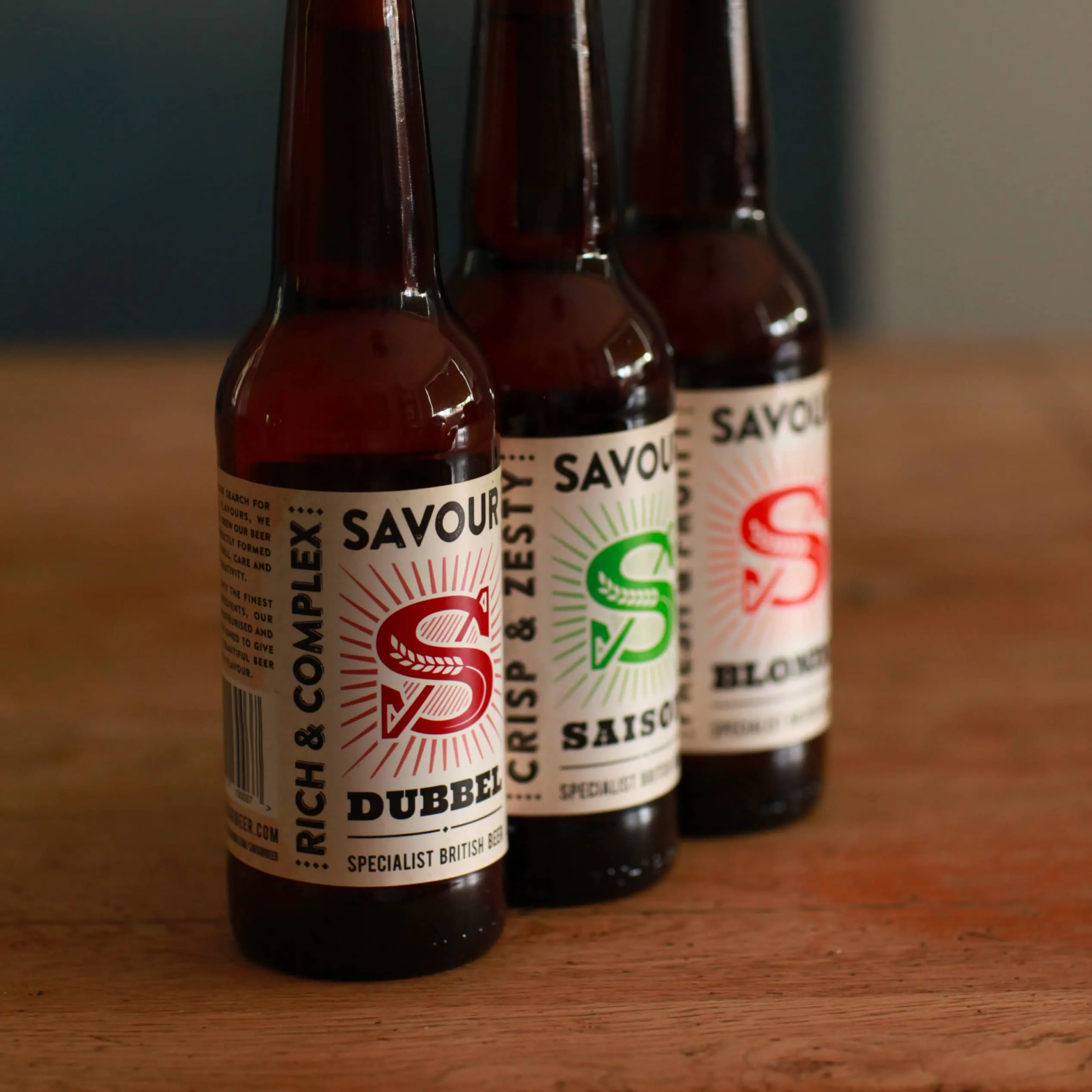 Savour beer bottle lineup showing different label colours and styles in shallow focus