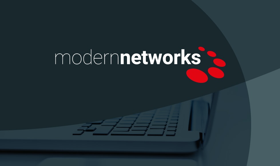 Modern Networks logo reversed out white from a grey background, which is made of grey-tinted curved shapes and a grey tinted image of a computer keyboard.