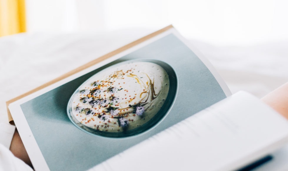 Recipe book perched in women's lap
