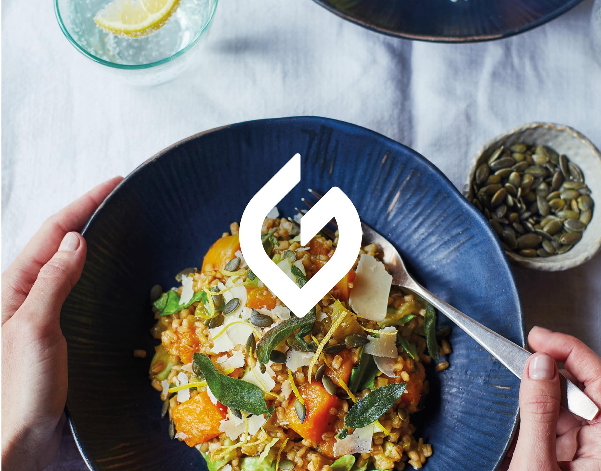 Overhead photo of a grain bowl with herbs and seeds, with The Gut Health Doctor logo overlay at centre
