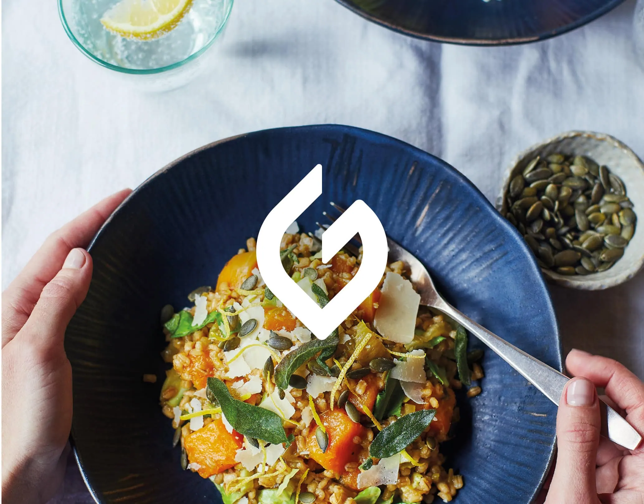 Overhead photo of a grain bowl with herbs and seeds, with The Gut Health Doctor logo overlay at centre
