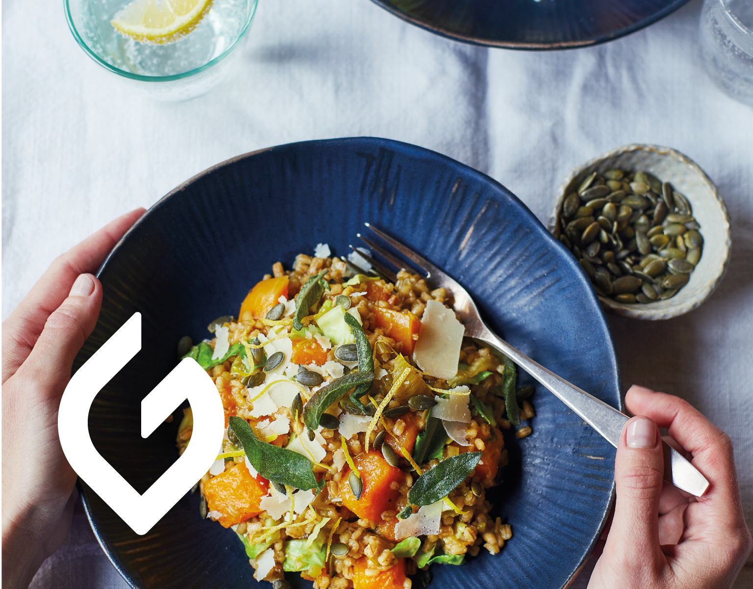 Overhead photo of a grain bowl with herbs and seeds, with The Gut Health Doctor logo overlay at centre