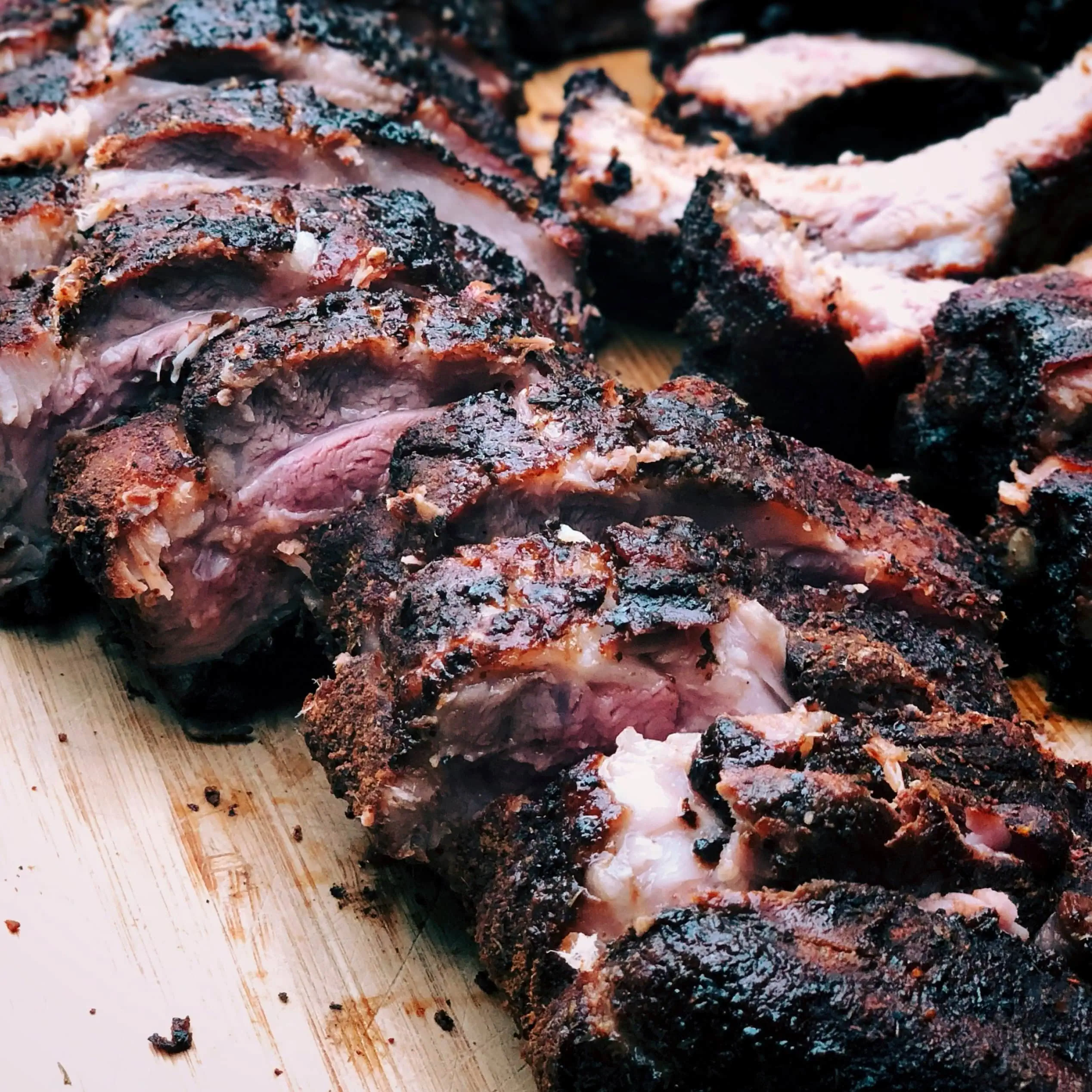 Close-up of smoked BBQ meat sliced on a wooden board