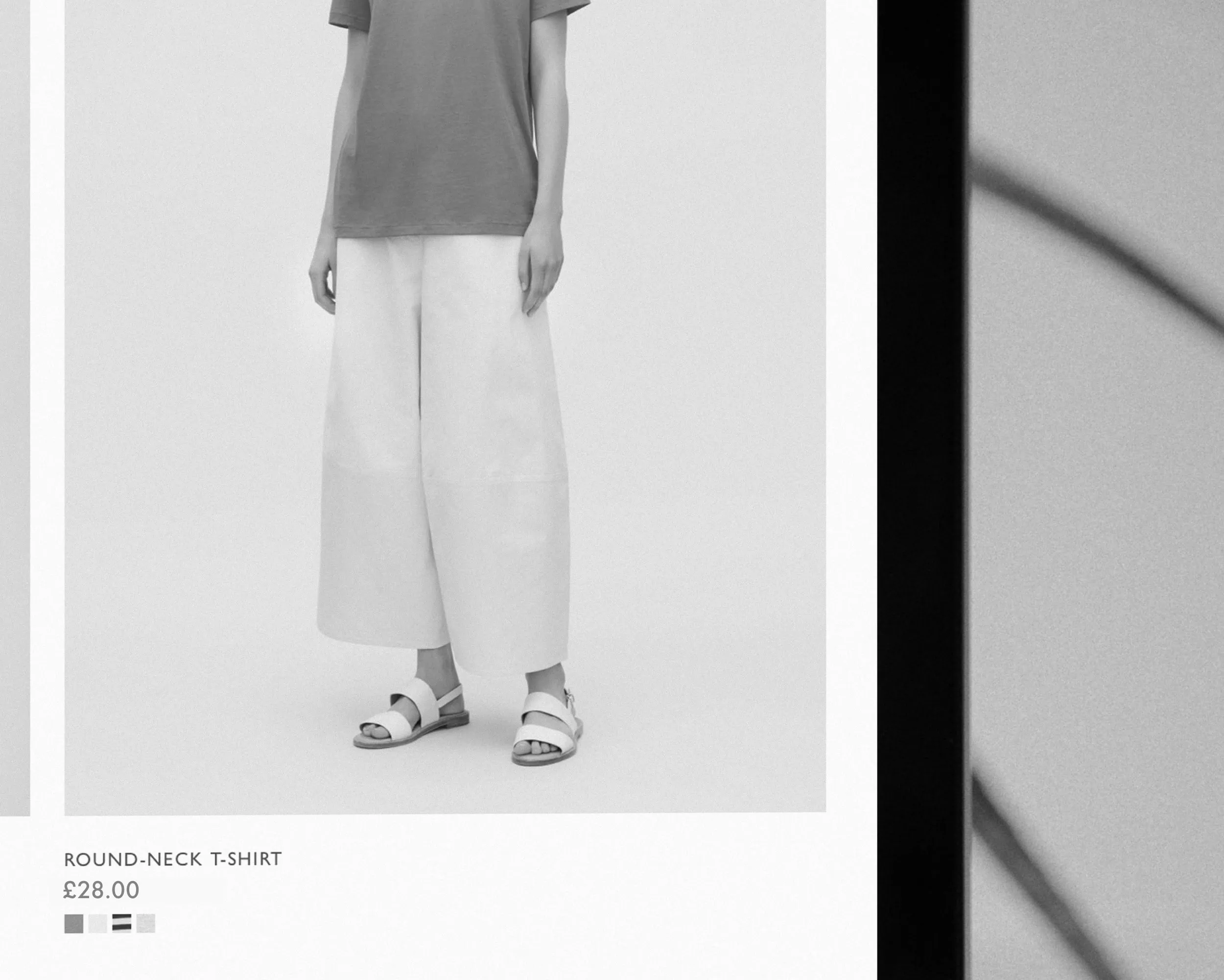 Ecommerce website page with model wearing a round-neck T-shirt with wide-leg trousers and sandals.