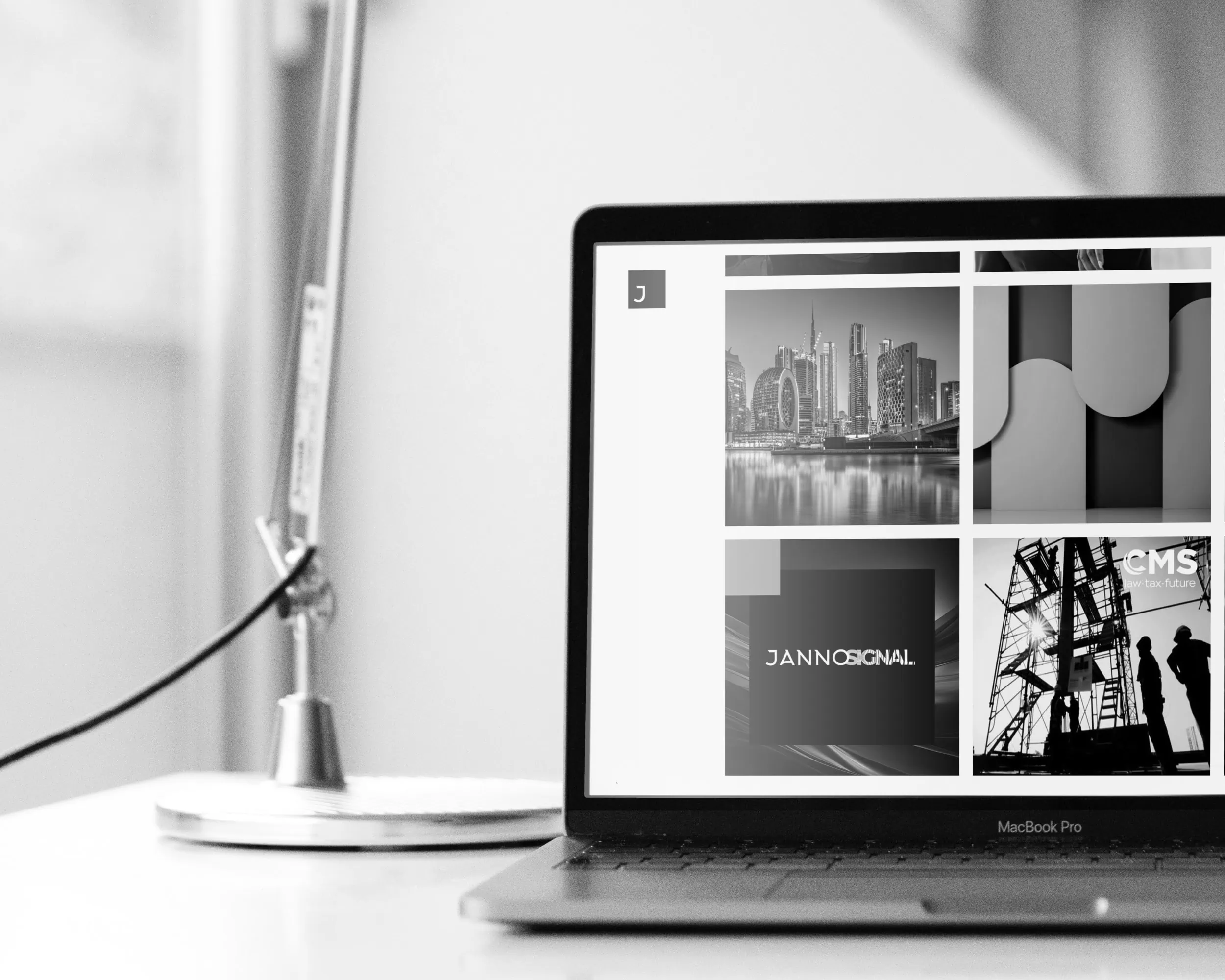 Laptop on a desk displaying a portfolio grid of project thumbnails on a website.